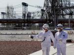 Dos trabajadores caminan frente a una planta nuclear ucraniana en funcionamiento.
