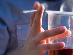 Un joven sujeta un cigarrillo y un vaso con alcohol.