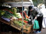 Un anciano compra en un mercado callejero de frutas y verduras en Buenos Aires.