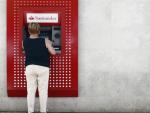 Imagen de recurso de una mujer saca dinero en un cajero del Banco Santander.
