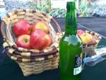 Manzanas, botella de sidra y vaso ancho para escanciarla