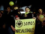 Cientos de personas protestan mostrando pancartas, en las inmediaciones del edificio de La Ingobernable en Madrid.