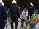 Agentes de polic&iacute;a griegos apartan a un grupo de refugiados en Mytilene.