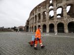 Un barrendero con mascarilla frente al Coliseo de Roma.