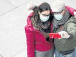 Una pareja se hace un selfi con mascarillas en Madrid.