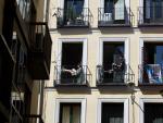 La fachada de una casa, en el centro de Madrid, con varios inquilinos en sus balcones.