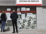 Dos personas leen los carteles de una oficina de empleo en Alcorc&oacute;n
