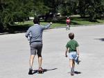 Un padre y un ni&ntilde;o con, ambos con patinete, en un parque de Madrid.