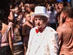 Un hombre vestido con un traje y un sombrero blanco, pasea por una calle de Bu&ntilde;ol, durante la fiesta de la Tomatina de Bu&ntilde;ol 2019.