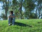 Adolescente sentado en la hierba.