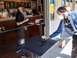 Un cliente recoge un caf&eacute; en una cafeter&iacute;a de Starbucks en McLean, Virginia (EE UU), reabierta tras el levantamiento en el estado de algunas de las restricciones impuestas por la pandemia del coronavirus.