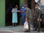 Un militar carga una raci&oacute;n de comida para una familia en el barrio desfavorecido de La Betania, en Tegucigalpa, Honduras, durante la pandemia del coronavirus.
