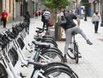 Un hombre coge una bicicleta de bicimad aparcada en una calle de la capital