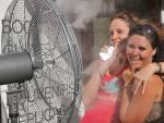 Do mujeres combaten el calor con un ventilador en plena calle