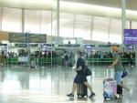 Personas con mascarilla en el aeropuerto del Prat.