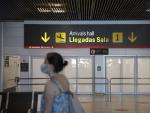 Una persona con mascarilla pasa junto a la entrada de la sala de llegadas 1 de la Terminal 1 del Aeropuerto de Barajas, en Madrid (Espa&ntilde;a) a 4 de julio de 2020.
