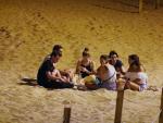 Un grupo de personas hacen botell&oacute;n en la playa de la Barceloneta.