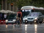 Un ciclista y varios turismos bajo la lluvia en la Avenidad del Paral&middot;lel de Barcelona, en una imagen de archivo.