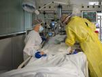 Dos sanitarios visitan a un paciente de Covid en la UCI del Hospital Cl&iacute;nic de Barcelona.