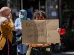 Una mujer, acompa&ntilde;ada por miembros de la Red vecinal de Apoyo Mutuo Ciutat Vella (Barcelona), sostiene una pancarta en la que se puede leer &quot;Renta b&aacute;sica garantizada&quot; en la concentraci&oacute;n el pasado 22 de mayo de 2020.