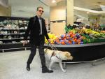 Persona ciega con perro gu&iacute;a en supermercado