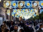 Varias personas disfrutan del encendido navide&ntilde;o en el centro de Sevilla.