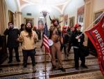 Varios asaltantes al congreso llegan a las puertas de la c&aacute;mara ataviados con atuendos de nativos americanos.