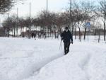 Un hombre camina por un vial creado en la nieve.