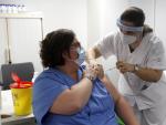 Una enfermera administra la vacuna Pfizer-BioNtech contra el COVID-19 a una profesional sanitaria en el Hospital Son Espases de Palma.