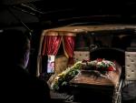 Trabajadores de una funeraria realizan una videollamada de WhatsApp con la esposa de un hombre, que muri&oacute; de Covid-19, para poder despedirse por &uacute;ltima vez en Sintra, Portugal.