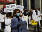 Una trabajadora sanitaria sostiene un cartel durante una concentraci&oacute;n convocada por la Asociaci&oacute;n de M&eacute;dicos y Titulados Superiores de Madrid (AMYTS), en la Puerta del Sol.
