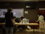 Una mujer desinfecta una mesa en un colegio electoral de Barcelona.