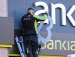 Un operario retira el r&oacute;tulo de Bankia de la sede principal del banco en Logro&ntilde;o este s&aacute;bado.
