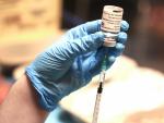 Una profesional sanitaria sostiene una jeringuilla con un vial de la vacuna contra la COVID-19 de AstraZeneca en un dispositivo de vacunaci&oacute;n en Bilbao.