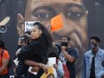 Dos personas se abrazan junto a un mural con la imagen de George Floyd en Atlanta (Georgia, EE UU), tras conocer el veredicto de culpabilidad emitido por el jurado contra el expolic&iacute;a Derek Chauvin por la muerte de Floyd en mayo de 2020.