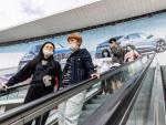 Visitantes con mascarillas por la pandemia de covid-19, en la Feria Internacional del Automóvil de Shanghái, China.
