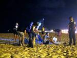 Un grupo de personas que hacía botellón en la playa de la Barceloneta se levata ante la presencia de agentes de la Guardia Urbana, en una imagen del 29 de julio de 2020.