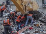 Operarios palestinos tratan de recuperar v&iacute;ctimas entre los escombros.