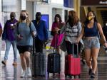 Viajeros con mascarillas por el coronavirus, en el aeropuerto Ronald Reagan de Washington, en Arlington, Virginia (EE UU).