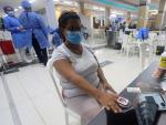 Una mujer comprueba su nivel de ox&iacute;geno durante una jornada de vacunaci&oacute;n masiva contra la covid-19 en centros comerciales en Cartagena de Indias (Colombia).