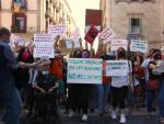 Manifestantes sosteniendo este lunes pancartas durante una manifestaci&oacute;n de trabajadoras sociales en la plaza Sant Jaume de Barcelona.