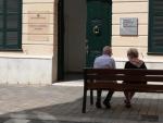 Imagen de archivo de dos personas mayores sentadas en un banco.