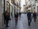 Varias personas caminan por el centro de Sevilla.
