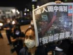 Una manifestante sostiene un ejemplar del diario 'Apple Daily' en Hong Kong, durante una protesta contra el cierre del peri&oacute;dico.