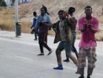 Varios inmigrantes subsaharianos celebran en Melilla tras conseguir saltar la valla fronteriza este jueves.