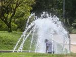 Un ni&ntilde;o se moja en una fuente en el parque de Madrid R&iacute;o.