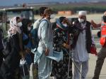 Varios afganos reciben indicaciones de la Polic&iacute;a A&eacute;rea espa&ntilde;ola tras aterrizar en la base de Torrej&oacute;n de Ardoz.
