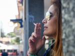 Una mujer fumando un cigarro.