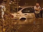 Un hombre trata de salir de su veh&iacute;culo tras las fuertes lluvias en Fuenlabrada.