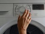 Imagen de archivo de una persona manipulando una secadora.